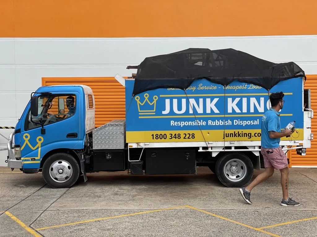 Junk King rubbish removal truck with a covered secured load