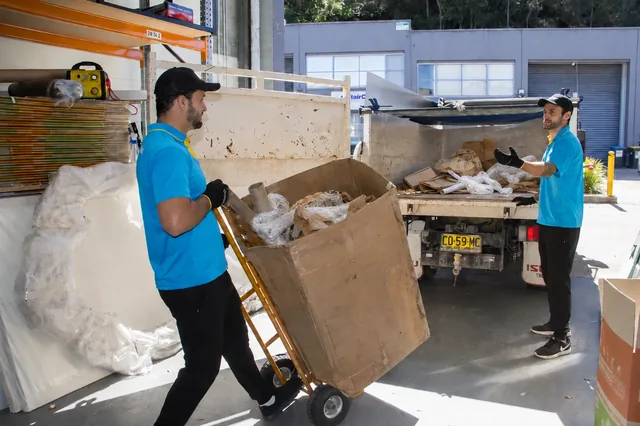 Junk King crew loading bulky items into the truck