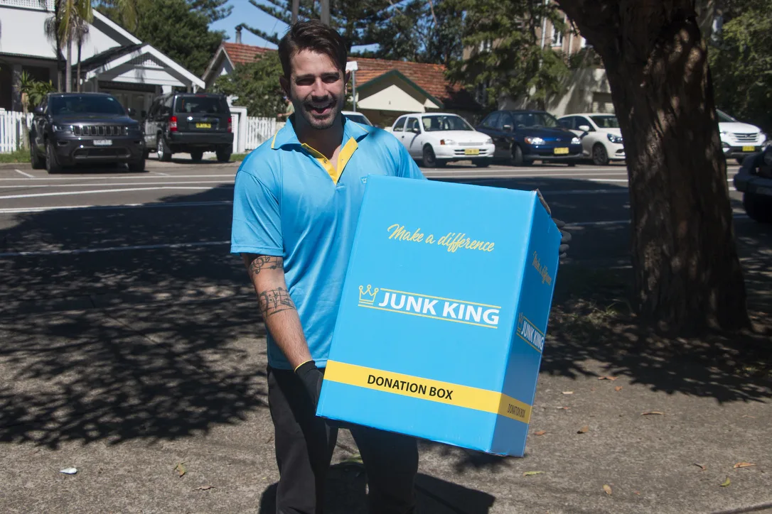 Junk King team member carrying a donation box