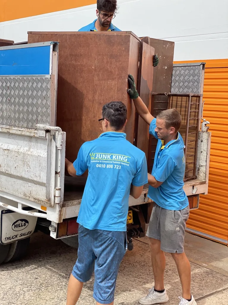 Junk King crew member loading furniture during a rubbish removal job
